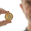 9qoyoqo5xi6hegm-golden-bitcoin-coin-in-hand-with-mans-face-1.jpg